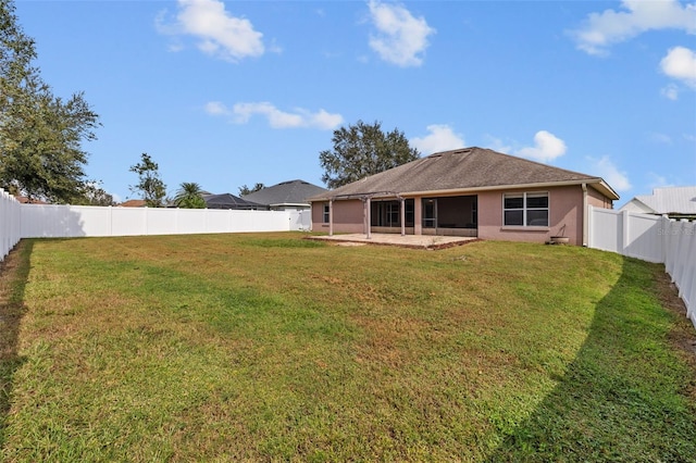 rear view of house featuring a yard and a patio area