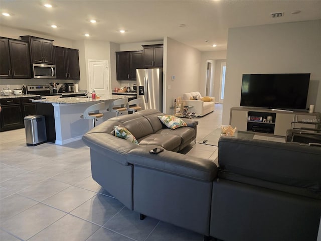 living area featuring light tile patterned floors, visible vents, and recessed lighting