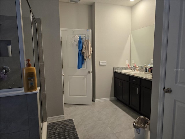 bathroom featuring vanity, a shower, and tile patterned flooring