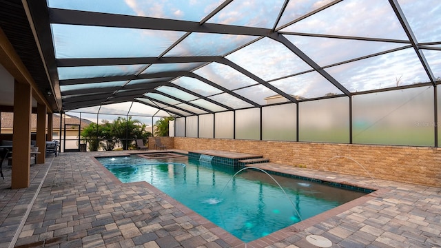 view of pool with glass enclosure, a patio, and pool water feature