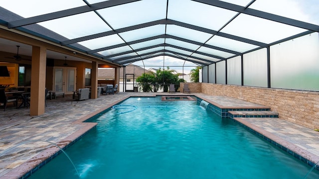 view of swimming pool featuring a lanai, french doors, pool water feature, and a patio area