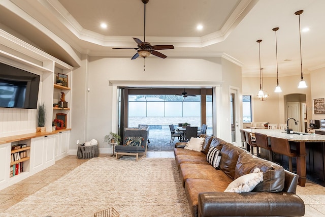 living room with built in shelves, sink, ceiling fan, and crown molding