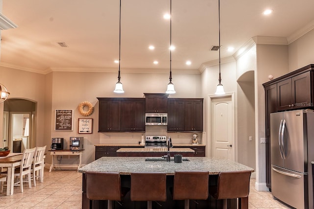 kitchen featuring stainless steel appliances, a center island with sink, sink, and pendant lighting