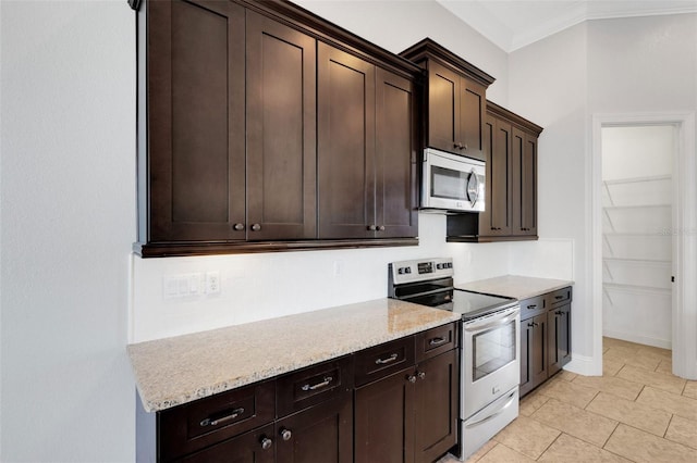 5074 Shore Side Dr, Lakeland, FL 33812 - kitchen featuring appliances with stainless steel finishes, dark brown cabinets, crown molding, light tile patterned floors, and light stone counters