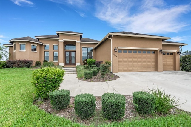 5074 Shore Side Dr, Lakeland, FL 33812 - prairie-style home with stucco siding, a garage, french doors, driveway, and a front lawn