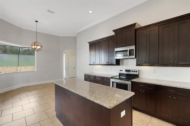 5074 Shore Side Dr, Lakeland, FL 33812 - kitchen featuring appliances with stainless steel finishes, a kitchen island, arched walkways, tasteful backsplash, and light tile patterned floors