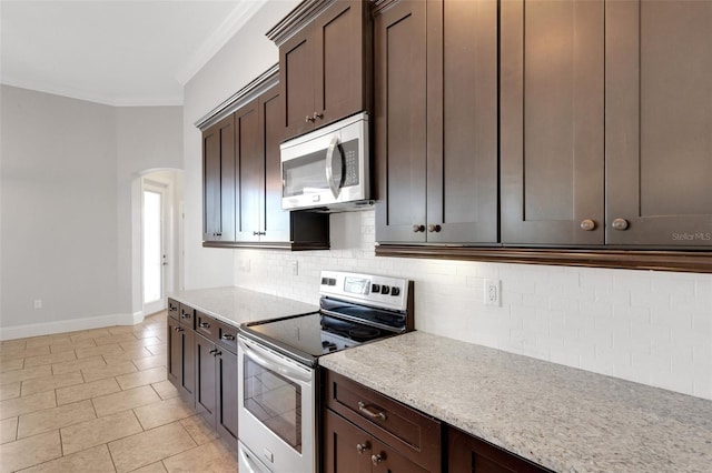 5074 Shore Side Dr, Lakeland, FL 33812 - kitchen with appliances with stainless steel finishes, arched walkways, crown molding, dark brown cabinets, and decorative backsplash