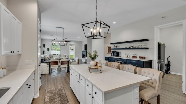 kitchen featuring blue cabinetry, a breakfast bar, white cabinets, and a center island