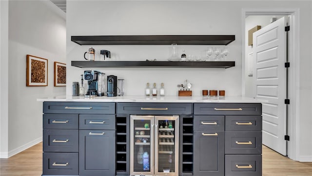 bar featuring wine cooler and light hardwood / wood-style floors