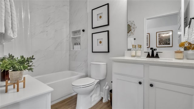 full bathroom featuring toilet, tiled shower / bath, vanity, and wood-type flooring