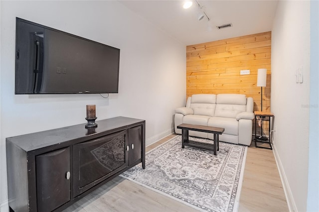 living room featuring light hardwood / wood-style floors and wood walls