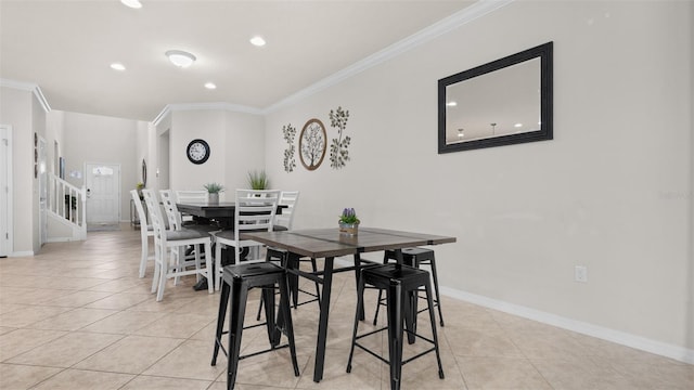 dining area featuring crown molding and light tile patterned flooring