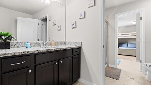 bathroom with tile patterned flooring, a shower with shower door, vanity, and toilet