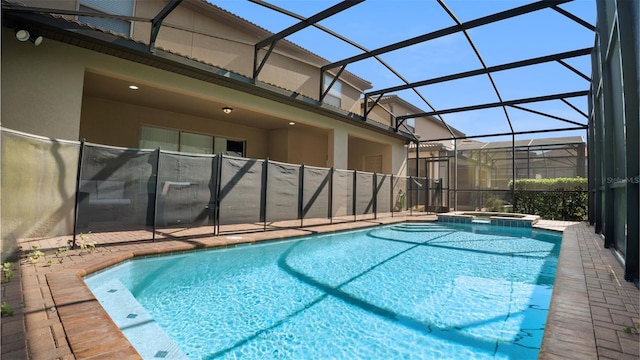 view of swimming pool featuring glass enclosure and an in ground hot tub