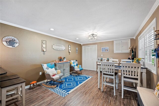 dining space with crown molding, wood-type flooring, a textured ceiling, and a notable chandelier