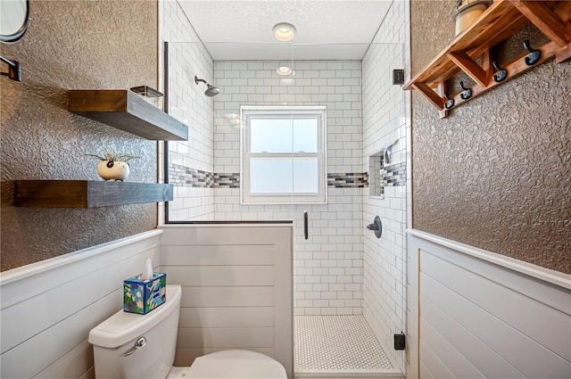 bathroom with a shower with shower door and toilet