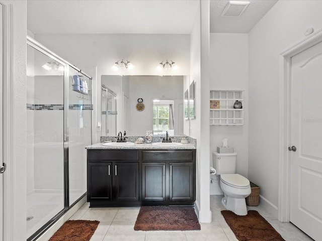 bathroom with tile patterned floors, toilet, an enclosed shower, and vanity