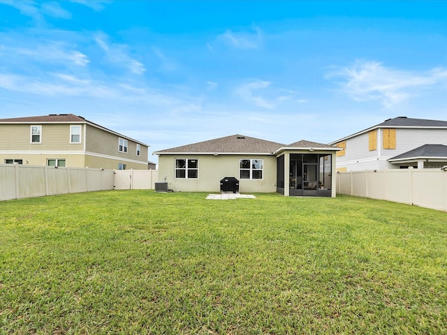 back of property with a patio area, a sunroom, a yard, and central AC unit