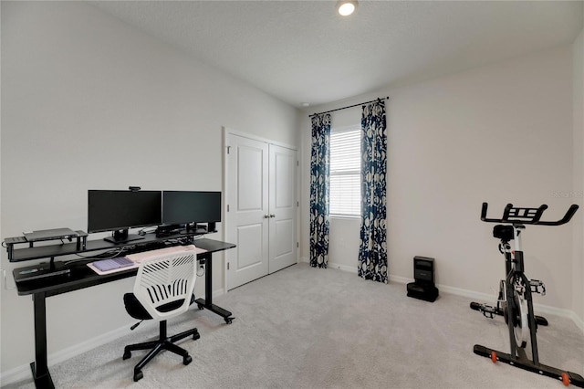 carpeted office space featuring a textured ceiling