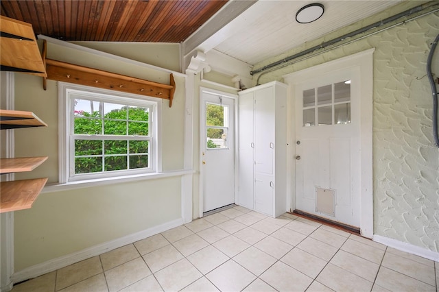 interior space featuring light tile patterned floors, wooden ceiling, and vaulted ceiling