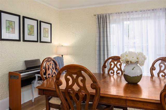 dining area with ornamental molding and wood-type flooring