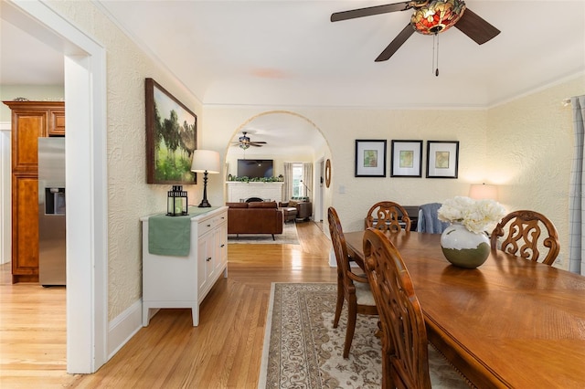 dining area with ceiling fan, light hardwood / wood-style flooring, and a fireplace