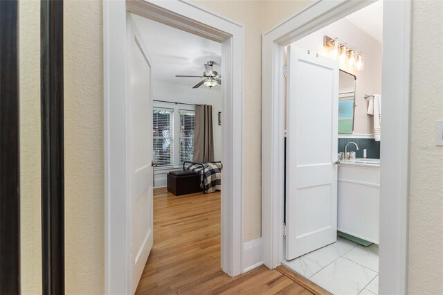 1806 17th St NW, Winter Haven, FL 33881 - hallway with light wood-style floors, a sink, and baseboards