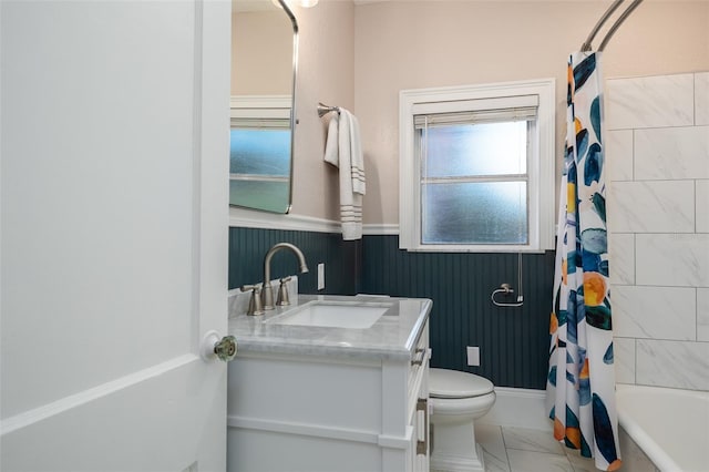 1806 17th St NW, Winter Haven, FL 33881 - bathroom featuring a wainscoted wall, vanity, marble look tiles, toilet, and shower / tub combo with curtain