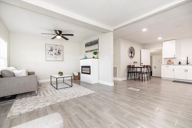 living room featuring light wood-type flooring and ceiling fan