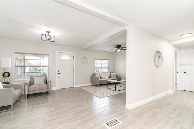 foyer with ceiling fan with notable chandelier and a healthy amount of sunlight