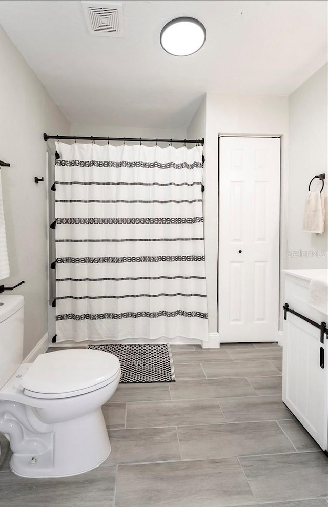 bathroom featuring vanity, toilet, and a shower with shower curtain