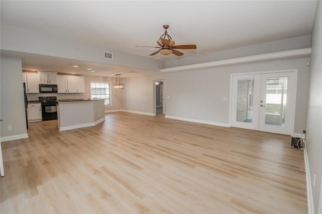 unfurnished living room featuring french doors, light hardwood / wood-style flooring, and ceiling fan