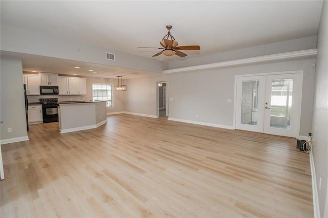 300 Winona Ct, Auburndale, FL 33823 - unfurnished living room featuring ceiling fan, french doors, light wood-style flooring, baseboards, and a chandelier