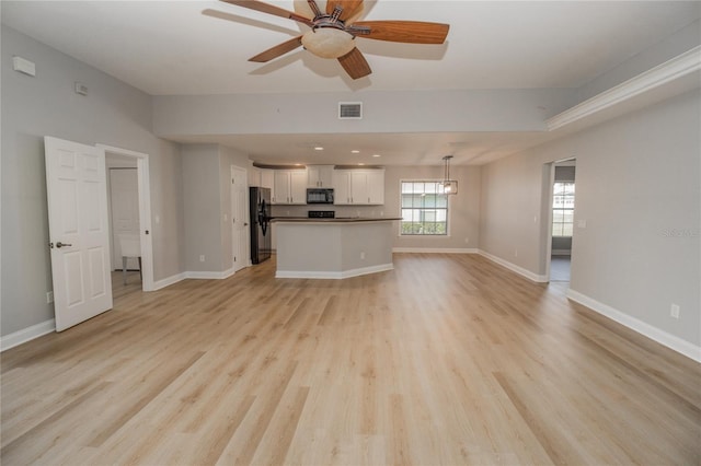 300 Winona Ct, Auburndale, FL 33823 - unfurnished living room with light wood-style flooring, a ceiling fan, and baseboards