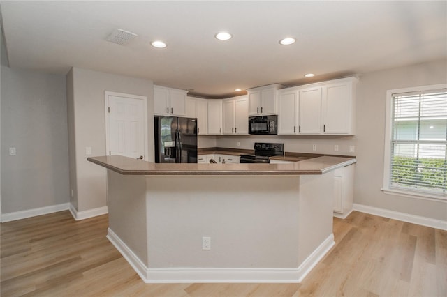 kitchen featuring white cabinetry, black appliances, and a center island with sink