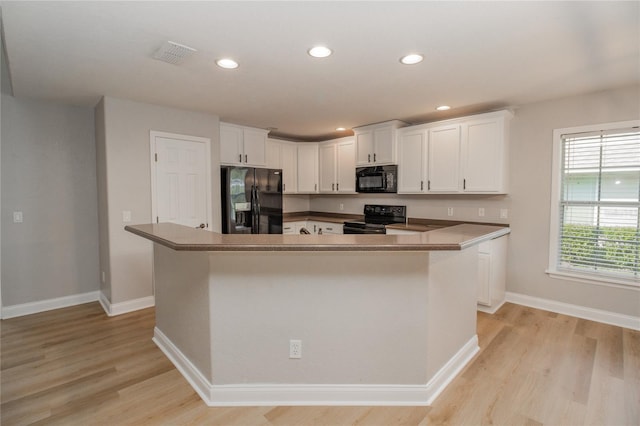 300 Winona Ct, Auburndale, FL 33823 - kitchen with black appliances, light wood-type flooring, a center island, white cabinets, and recessed lighting