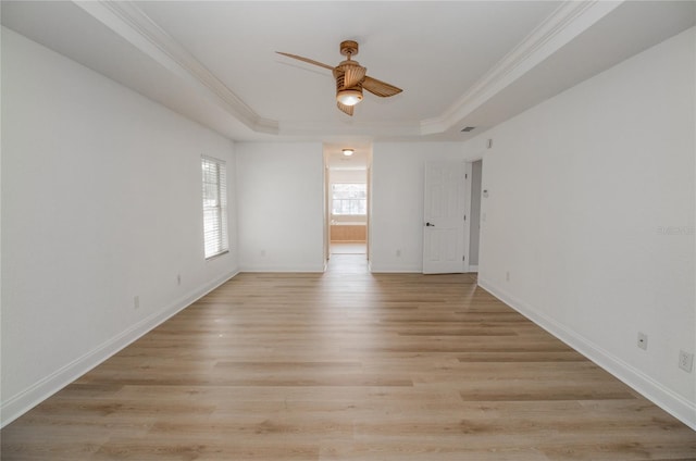 unfurnished room with crown molding, a tray ceiling, and light hardwood / wood-style flooring