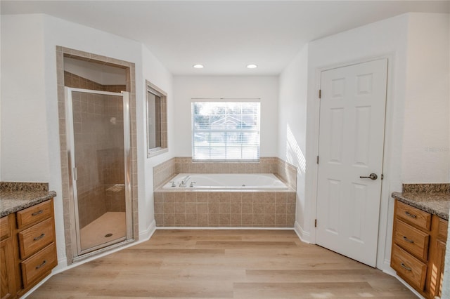 300 Winona Ct, Auburndale, FL 33823 - bathroom with a stall shower, vanity, a garden tub, wood finished floors, and recessed lighting