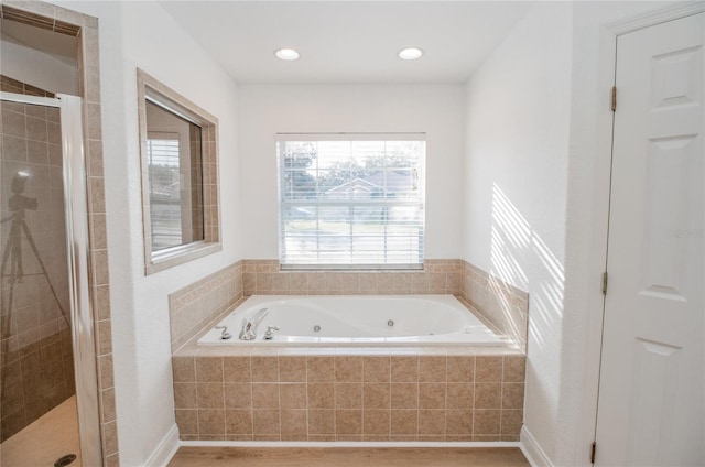 bathroom featuring wood-type flooring and separate shower and tub