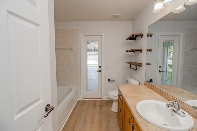 bathroom featuring a wealth of natural light, vanity, hardwood / wood-style flooring, and toilet