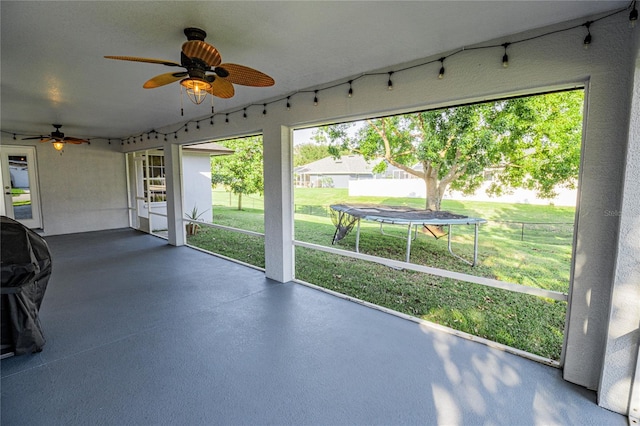 unfurnished sunroom featuring ceiling fan