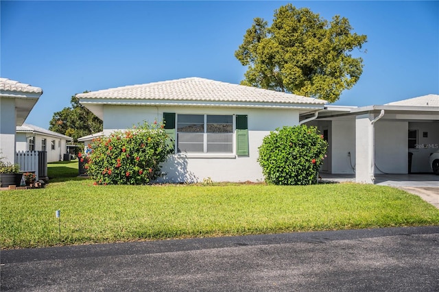 view of front of home featuring a front lawn and a carport