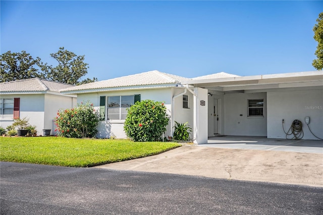 single story home featuring a front lawn and a carport