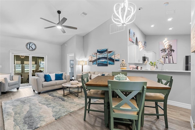 interior space with high vaulted ceiling, ceiling fan with notable chandelier, and light wood-type flooring