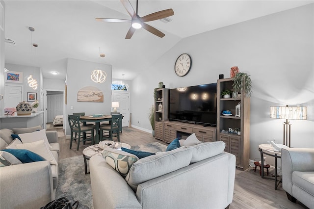 living room featuring light hardwood / wood-style floors, lofted ceiling, and ceiling fan