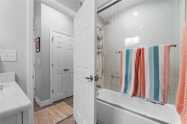 bathroom featuring tiled shower / bath, vanity, and hardwood / wood-style flooring