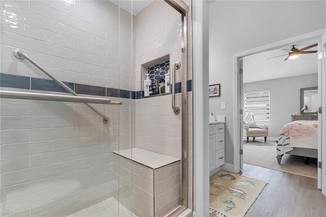 bathroom with vanity, a shower with shower door, wood-type flooring, and ceiling fan