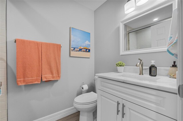 bathroom with vanity, toilet, walk in shower, and hardwood / wood-style floors