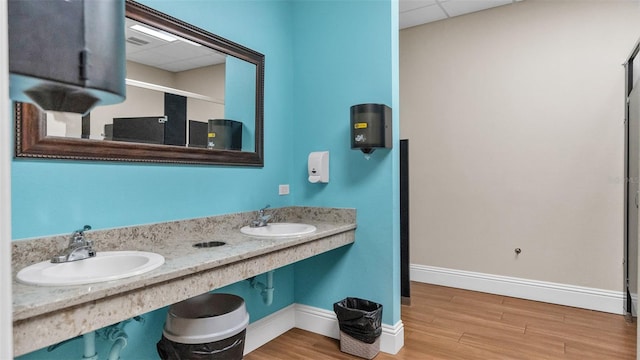 bathroom with hardwood / wood-style floors, sink, a drop ceiling, and an enclosed shower