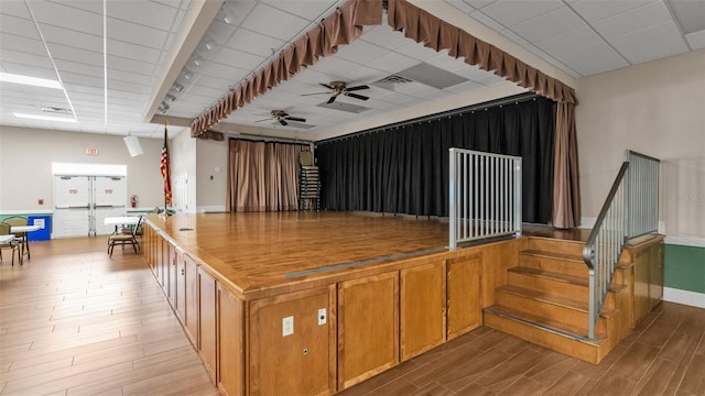 interior space featuring a paneled ceiling, ceiling fan, and light wood-type flooring